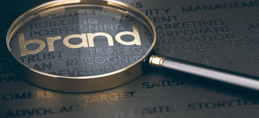 A magnifying glass over golden and black words.
