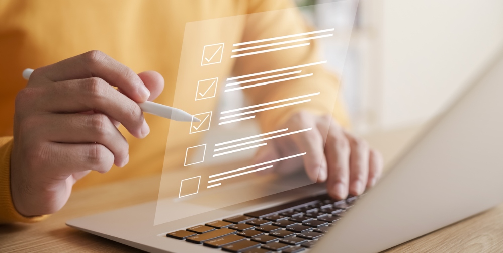 Businessman using laptop doing online checklist survey