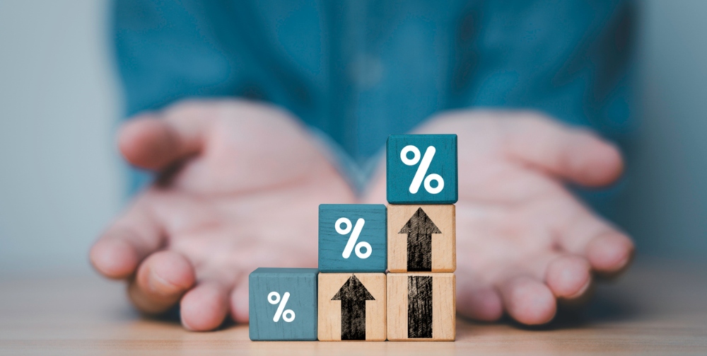 Businessman hand giving increasing percentage with up arrow on wooden block cube 