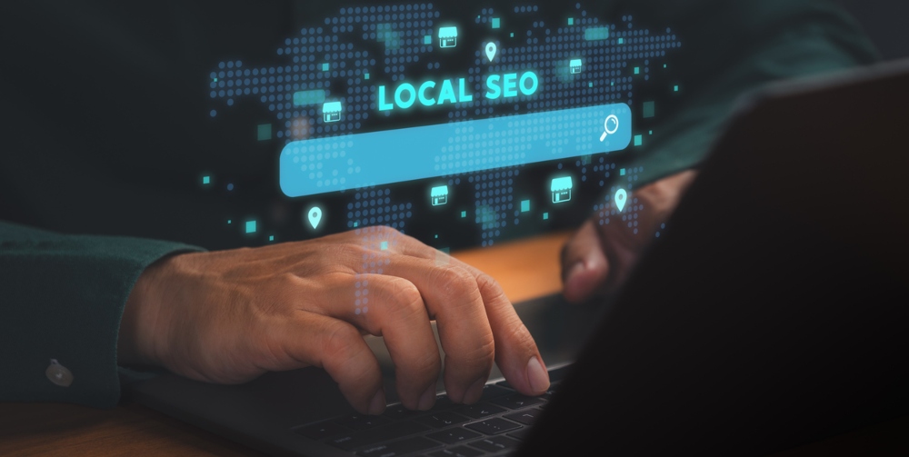 Person using laptop with glowing Local SEO search bar, 